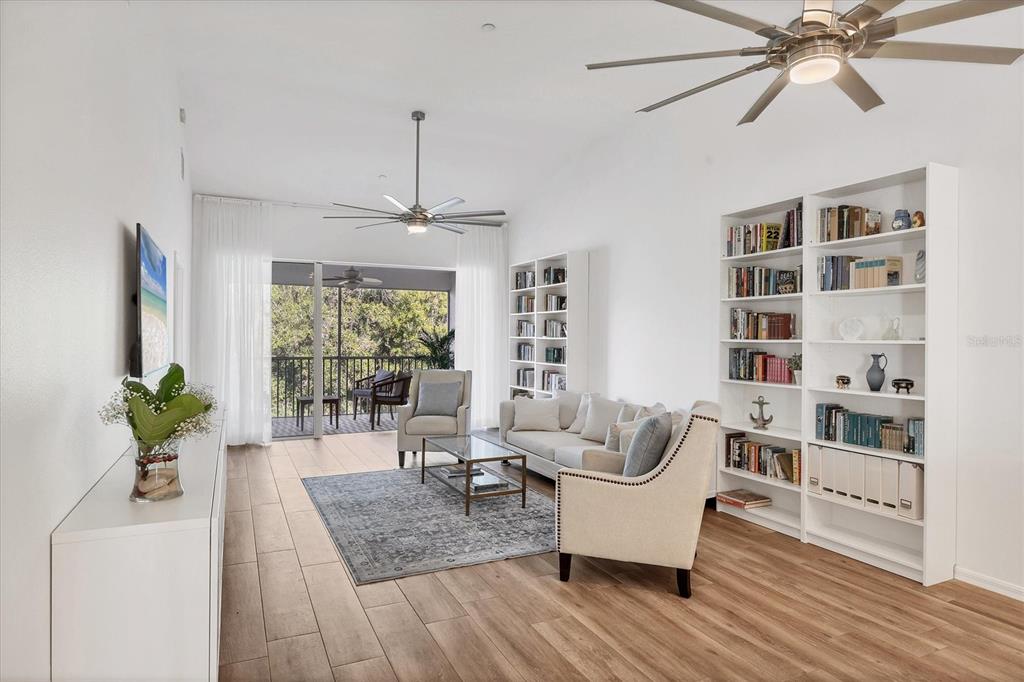 7131 Boca Grove Place, Unit 203 Lakewood Ranch, FL 34202 - Photo 3 of 50 a living room with furniture or chandelier and a wooden floor
