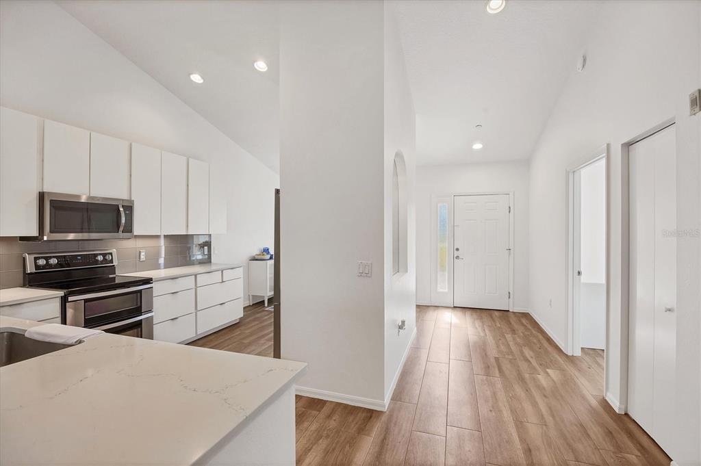 7131 Boca Grove Place, Unit 203 Lakewood Ranch, FL 34202 - Photo 4 of 50 a kitchen with a refrigerator stove and wooden floor