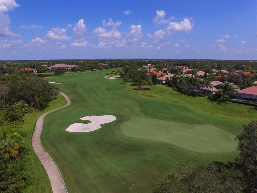 7131 Boca Grove Place, Unit 203 Lakewood Ranch, FL 34202 - Photo 48 of 50 a view of a lake with a house in the background