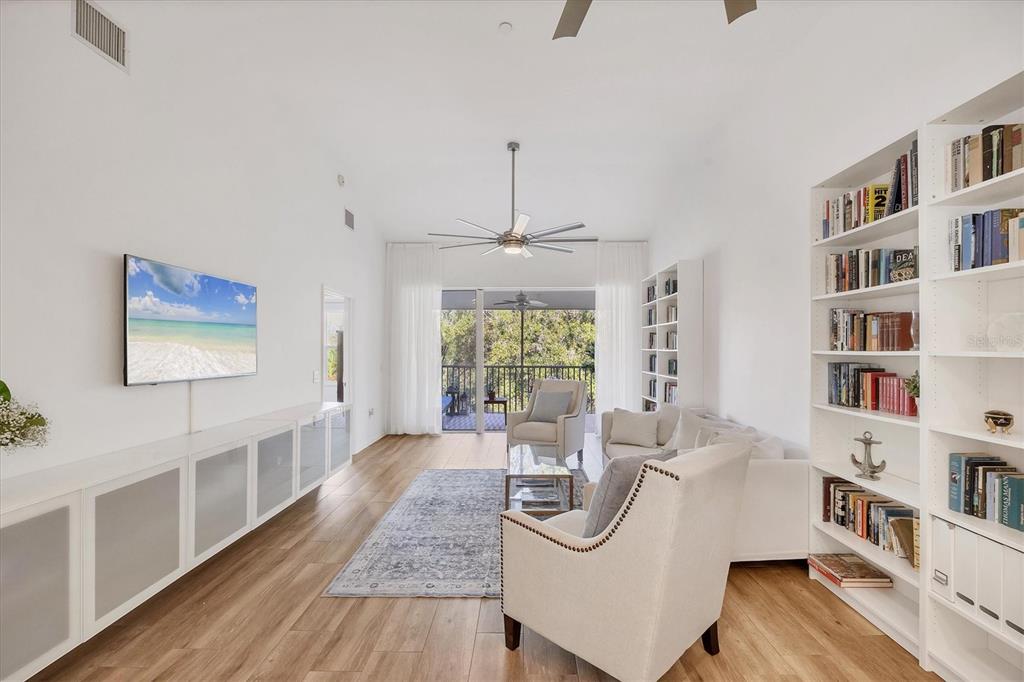 7131 Boca Grove Place, Unit 203 Lakewood Ranch, FL 34202 - Photo 5 of 50 a living room with furniture and a book shelf