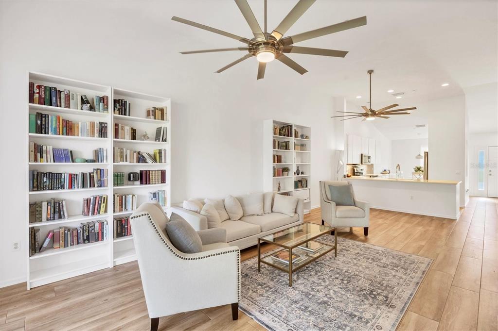 7131 Boca Grove Place, Unit 203 Lakewood Ranch, FL 34202 - Photo 7 of 50 a living room with furniture and a book shelf