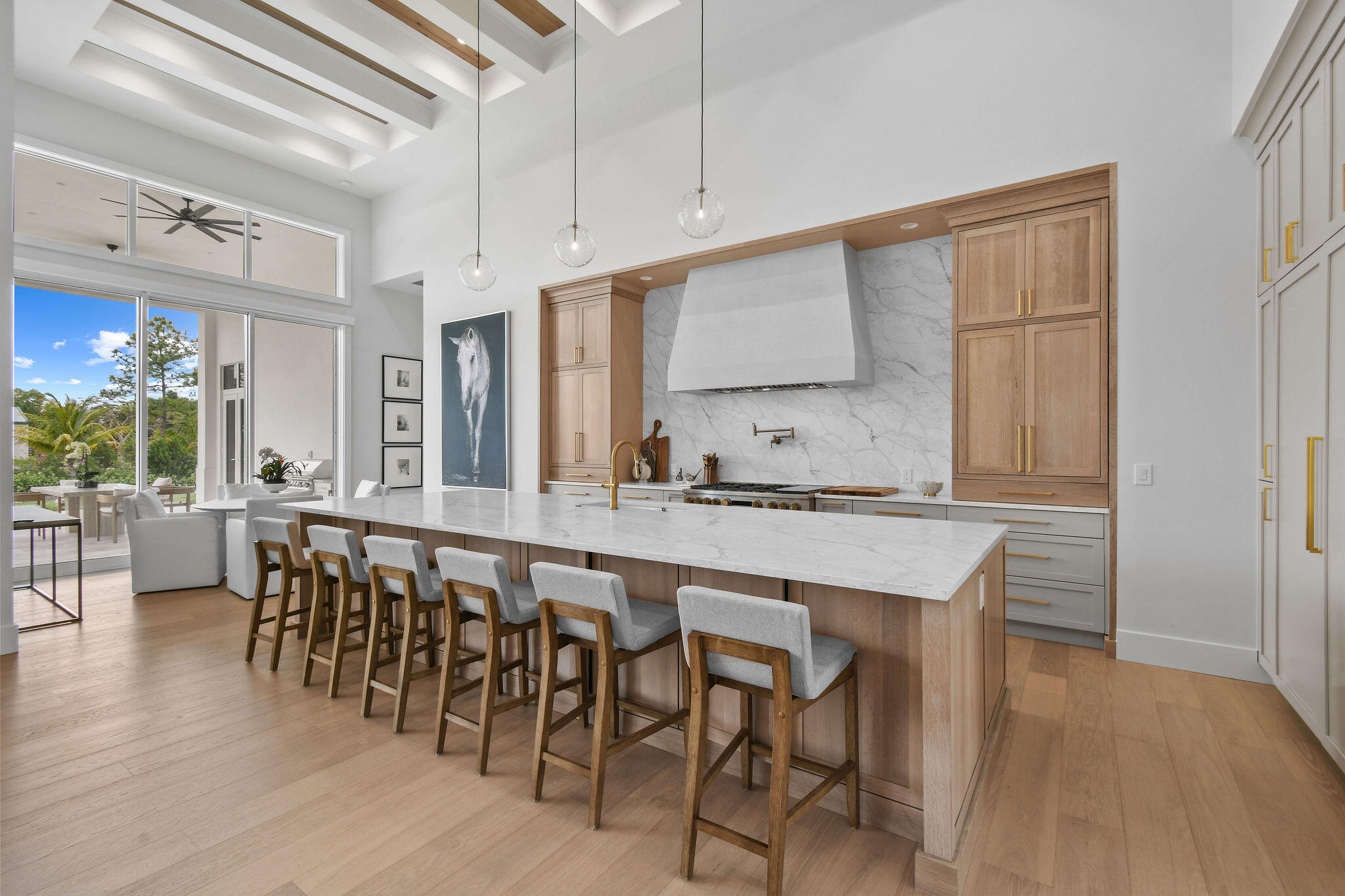 9105 Whippoorwill Trail Jupiter, FL 33478 - Photo 11 of 60 a dining hall with stainless steel appliances granite countertop a stove a sink a dining table and chairs with wooden floor