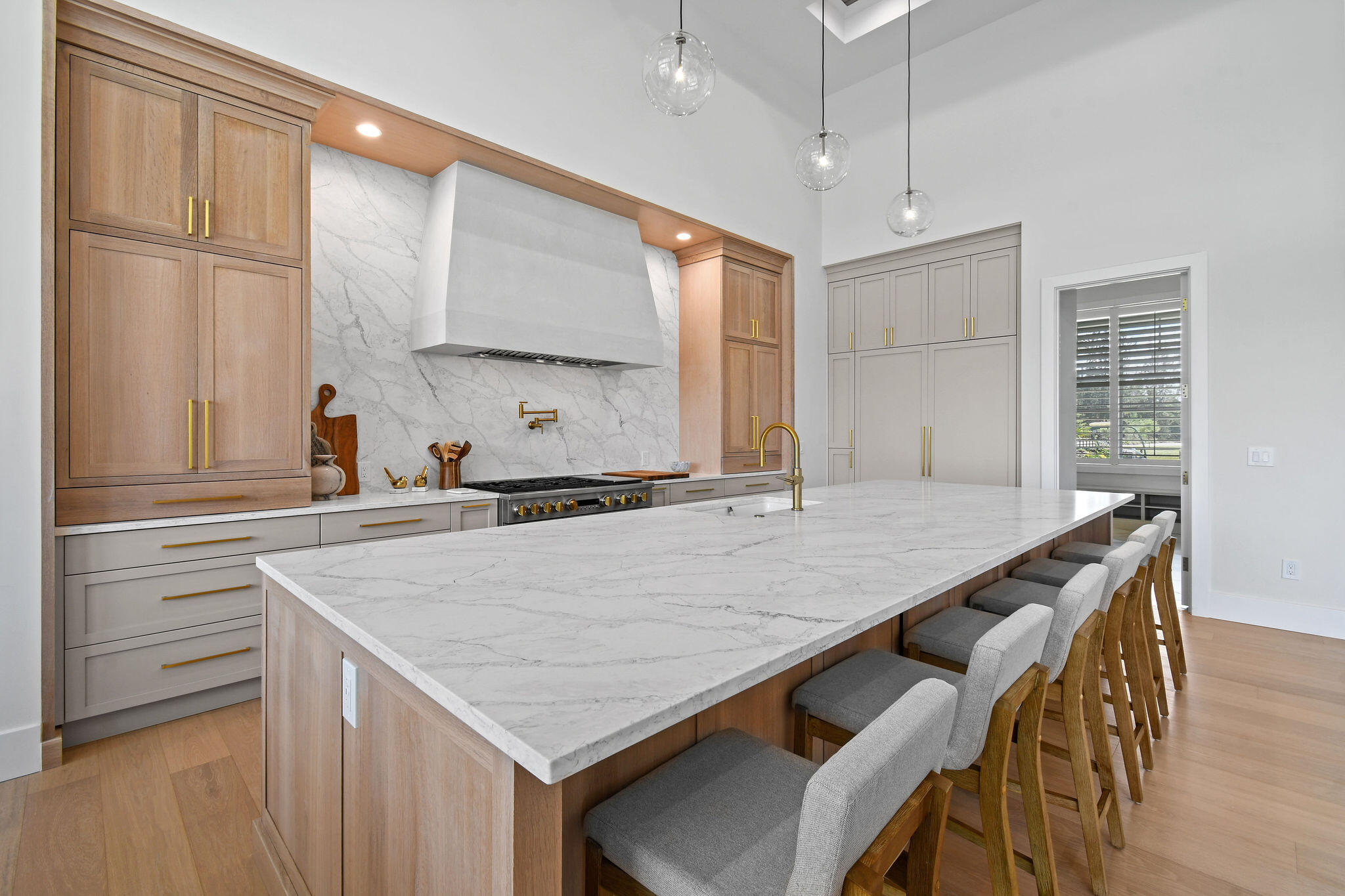 9105 Whippoorwill Trail Jupiter, FL 33478 - Photo 14 of 60 a kitchen with kitchen island a wooden floor and white cabinets