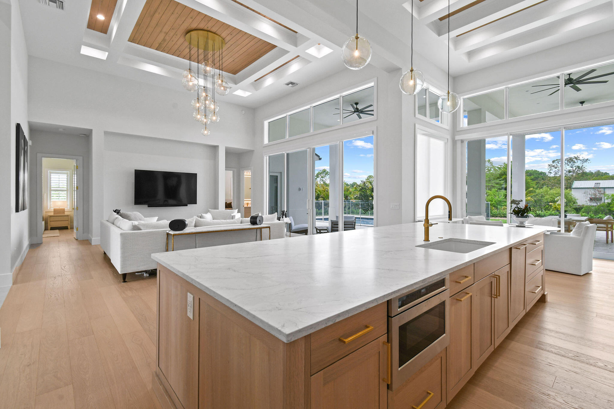 9105 Whippoorwill Trail Jupiter, FL 33478 - Photo 18 of 60 a large kitchen with kitchen island a large counter space a sink appliances and a view of living room