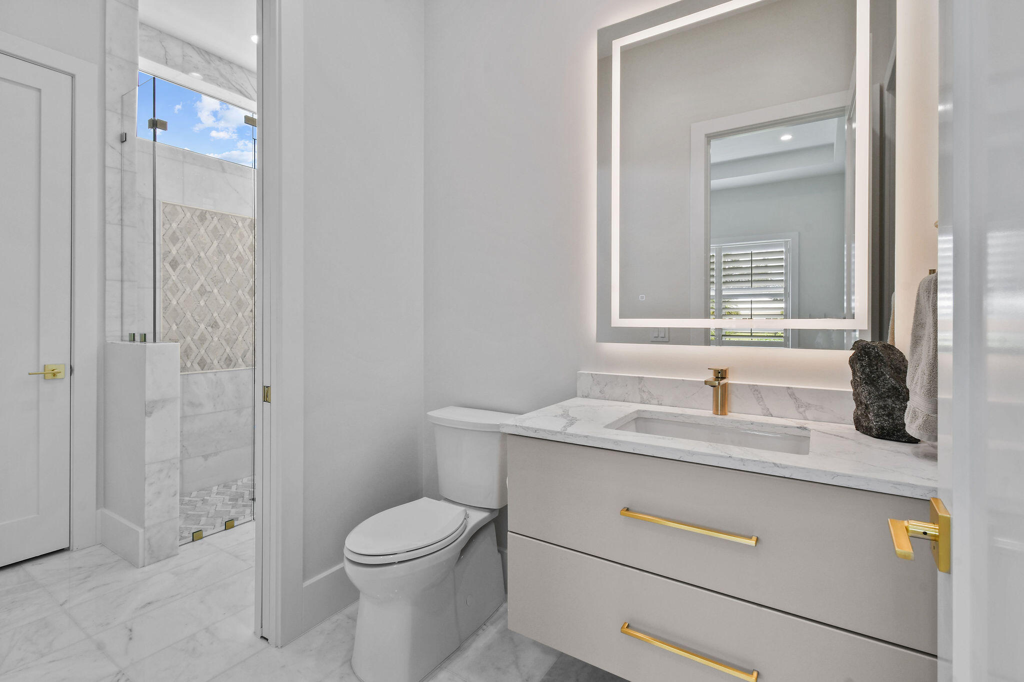 9105 Whippoorwill Trail Jupiter, FL 33478 - Photo 37 of 60 a bathroom with a granite countertop toilet sink and mirror