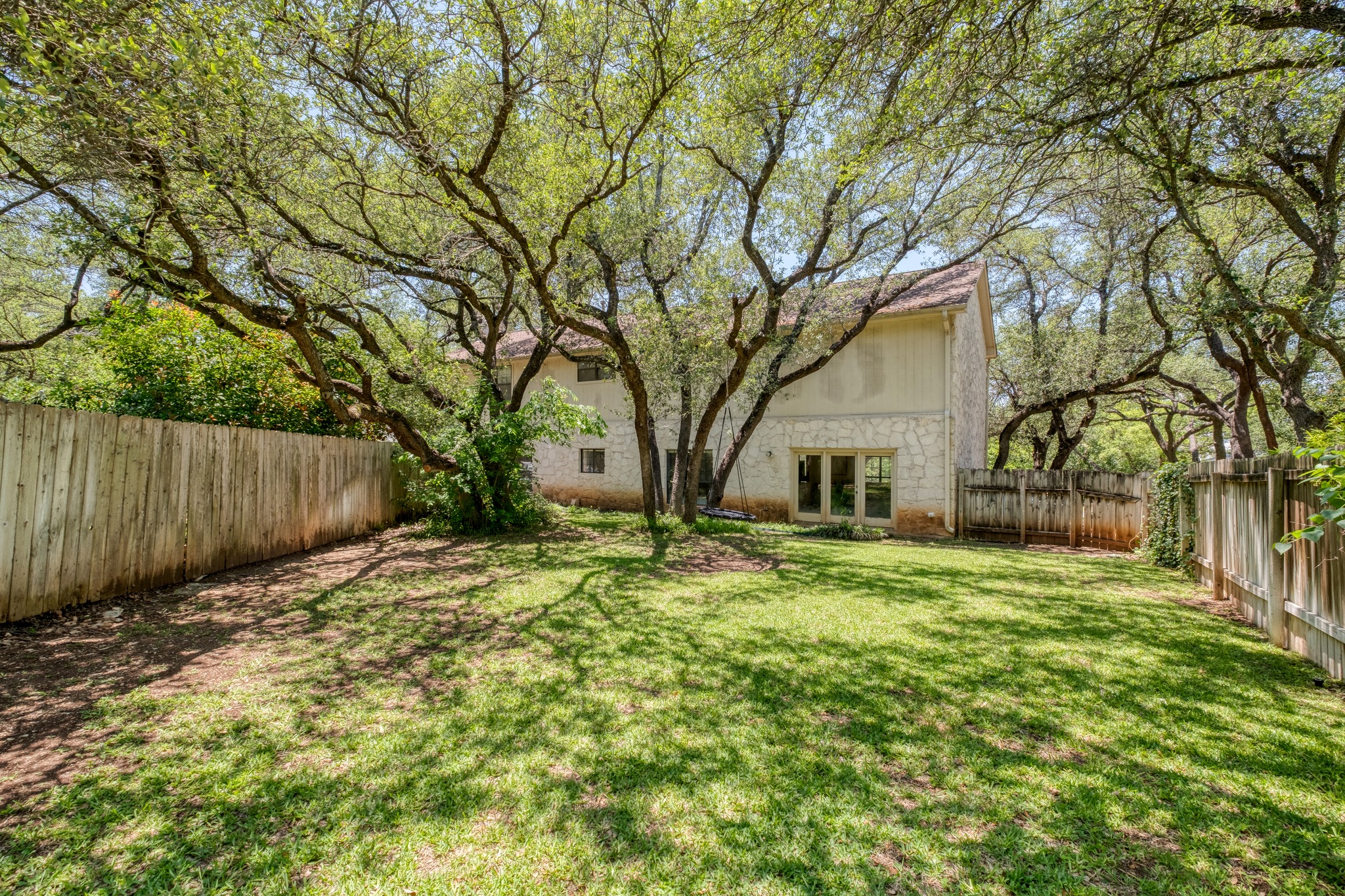 202 Ridgewood Drive Georgetown, TX 78628 - Photo 36 of 40 Expansive backyard featuring a manicured lawn, mature trees providing natural shade, and a privacy fence