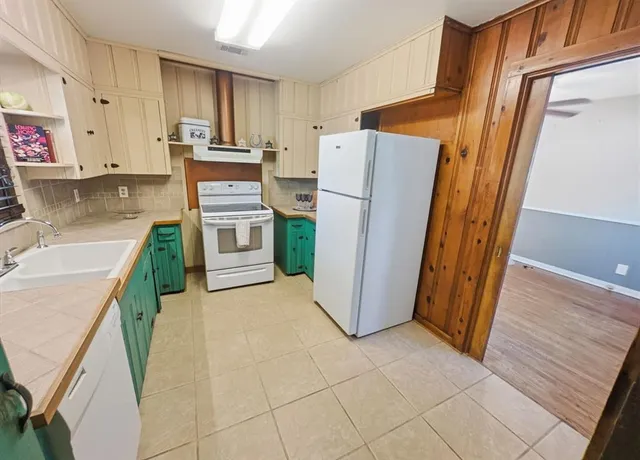 a kitchen with a refrigerator sink stove and cabinets
