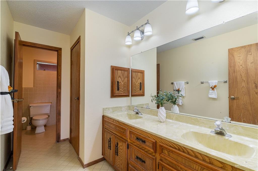 1100 Xanthisma Avenue McAllen, TX 78504 - Photo 13 of 26 a bathroom with a double vanity sink and a mirror