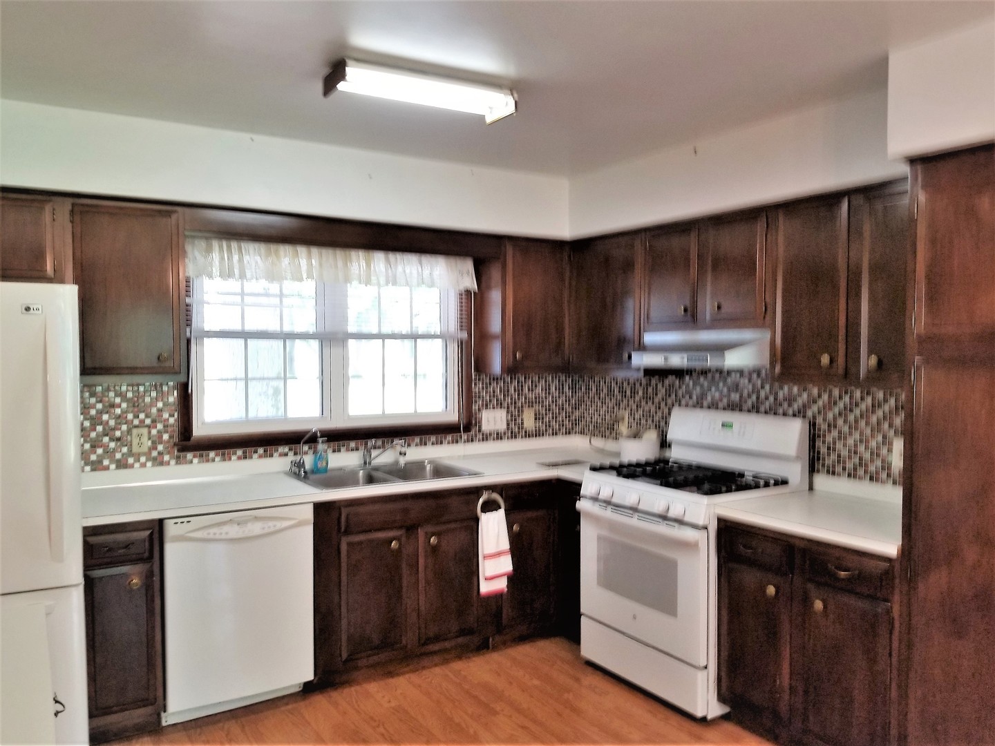 16210 Strawberry Road Morrison, IL 61270 - Photo 3 of 17 a kitchen with a stove a sink a window and cabinets