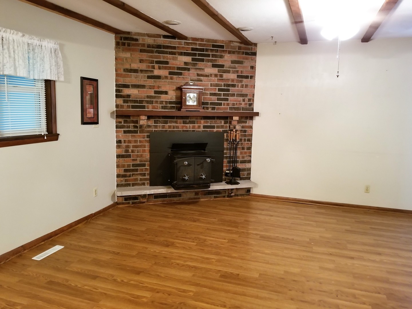 16210 Strawberry Road Morrison, IL 61270 - Photo 7 of 17 a view of an empty room with wooden floor and a fireplace