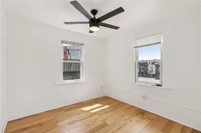 an empty room with a window and a ceiling fan