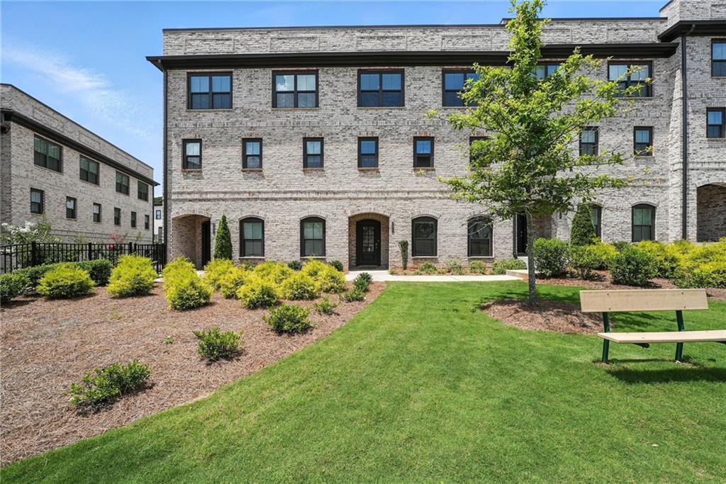 a large white house with a yard and a table under it