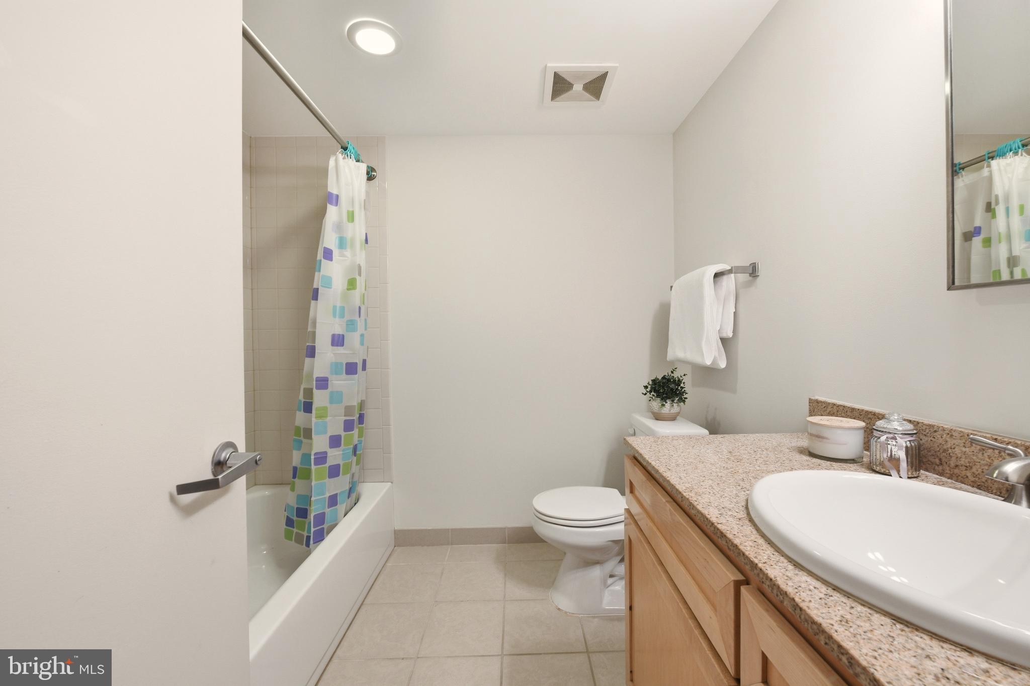 1150 K Street Northwest, Unit 1109 Washington, DC 20005 - Photo 16 of 33 a bathroom with a granite countertop sink toilet and shower