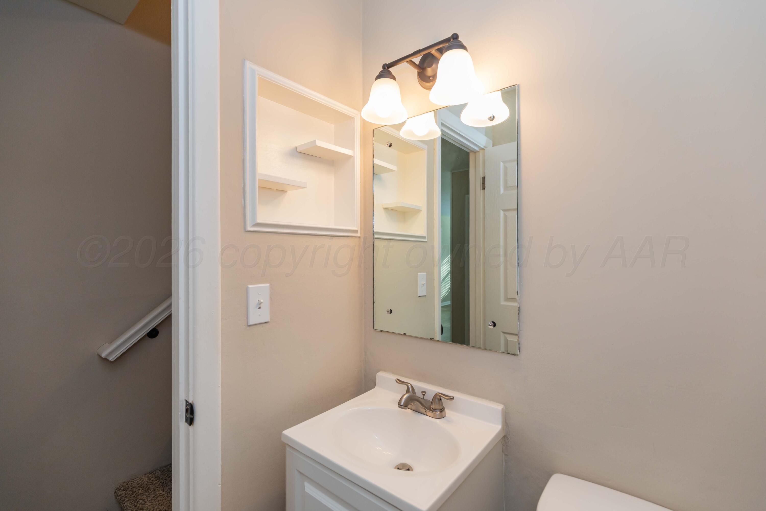 105 Smith Street Borger, TX 79007 - Photo 11 of 26 a bathroom with a sink mirror and vanity