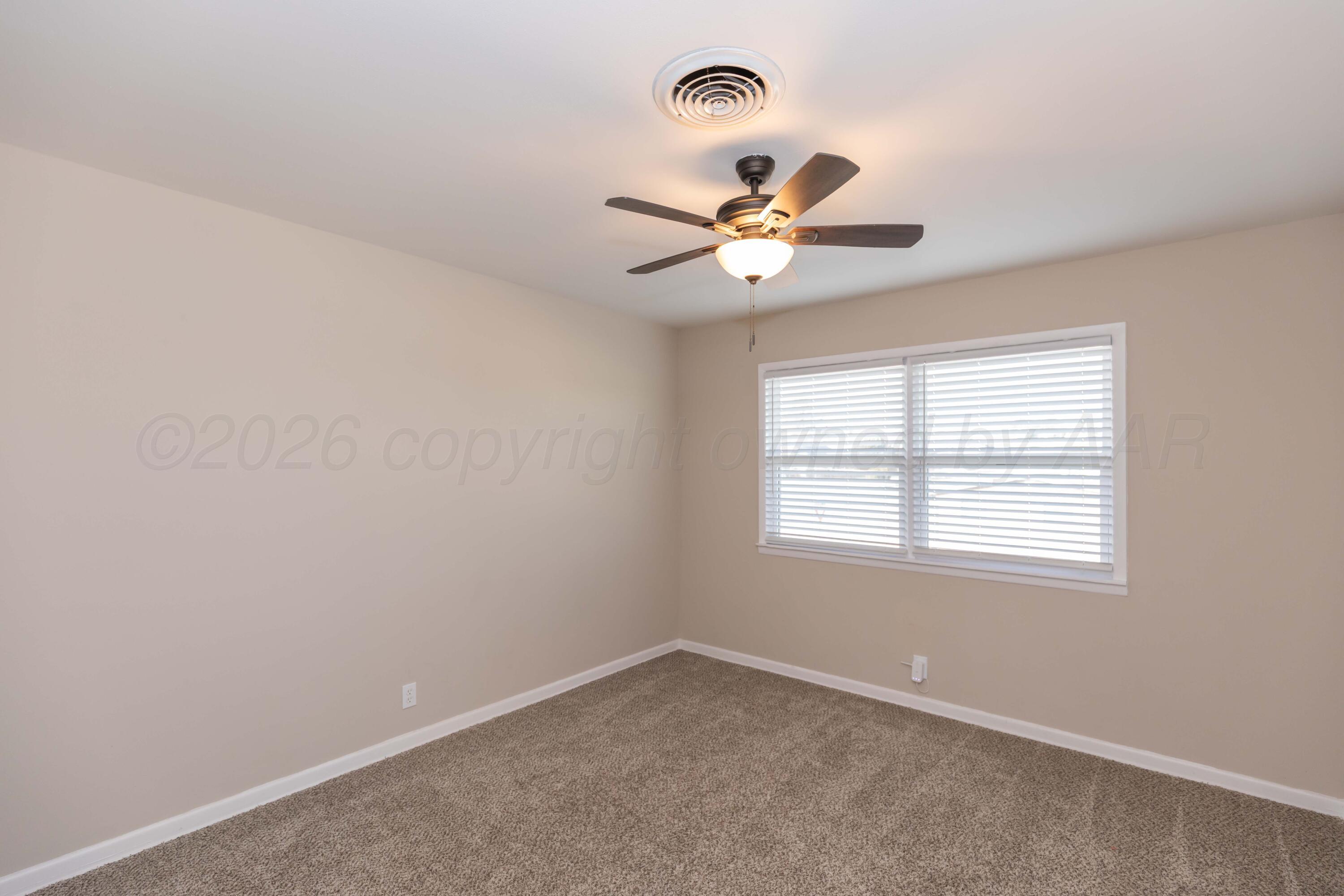 105 Smith Street Borger, TX 79007 - Photo 16 of 26 an empty room with a window and a fan