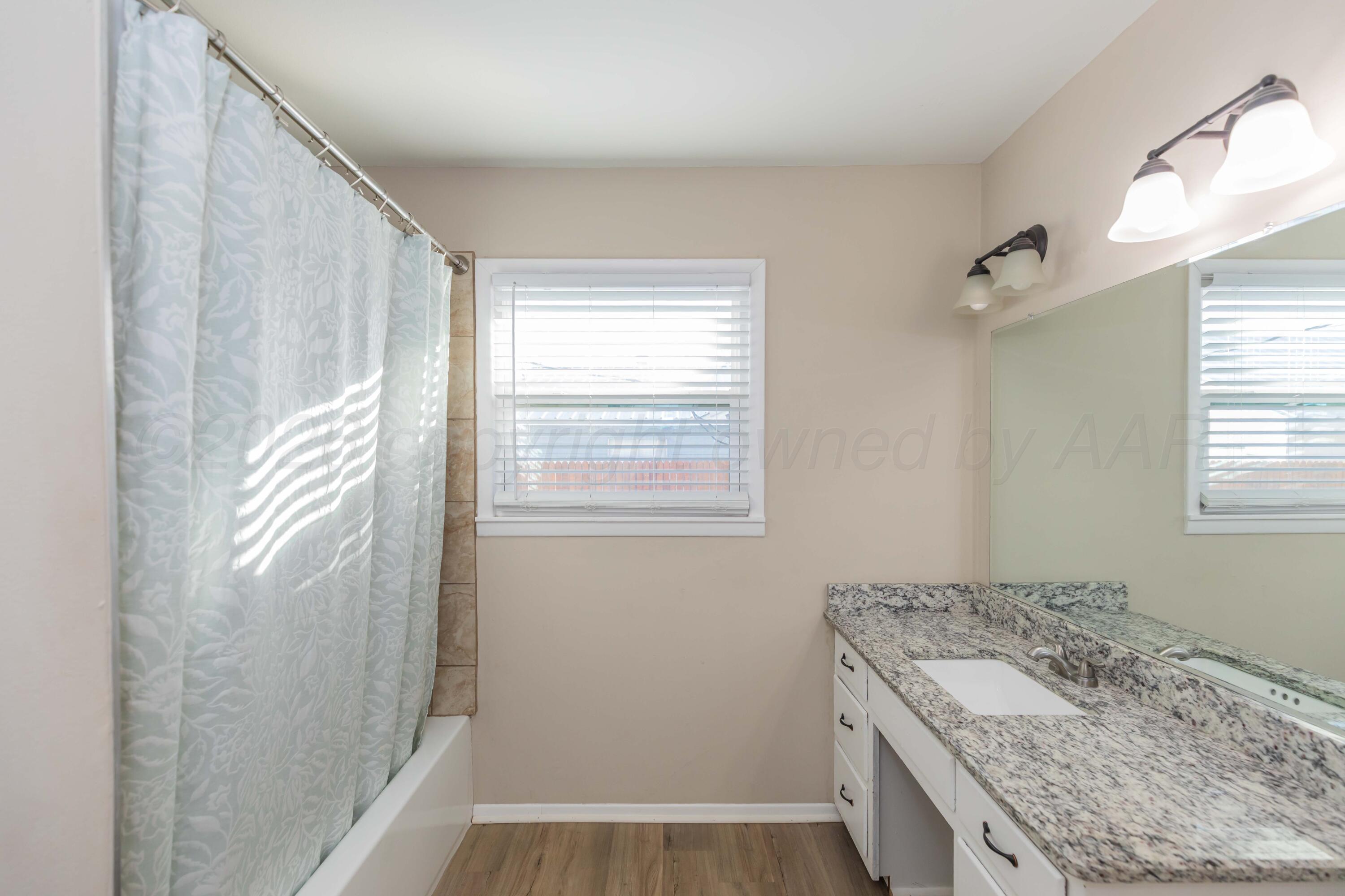 105 Smith Street Borger, TX 79007 - Photo 21 of 26 a bathroom with a granite countertop sink and a mirror