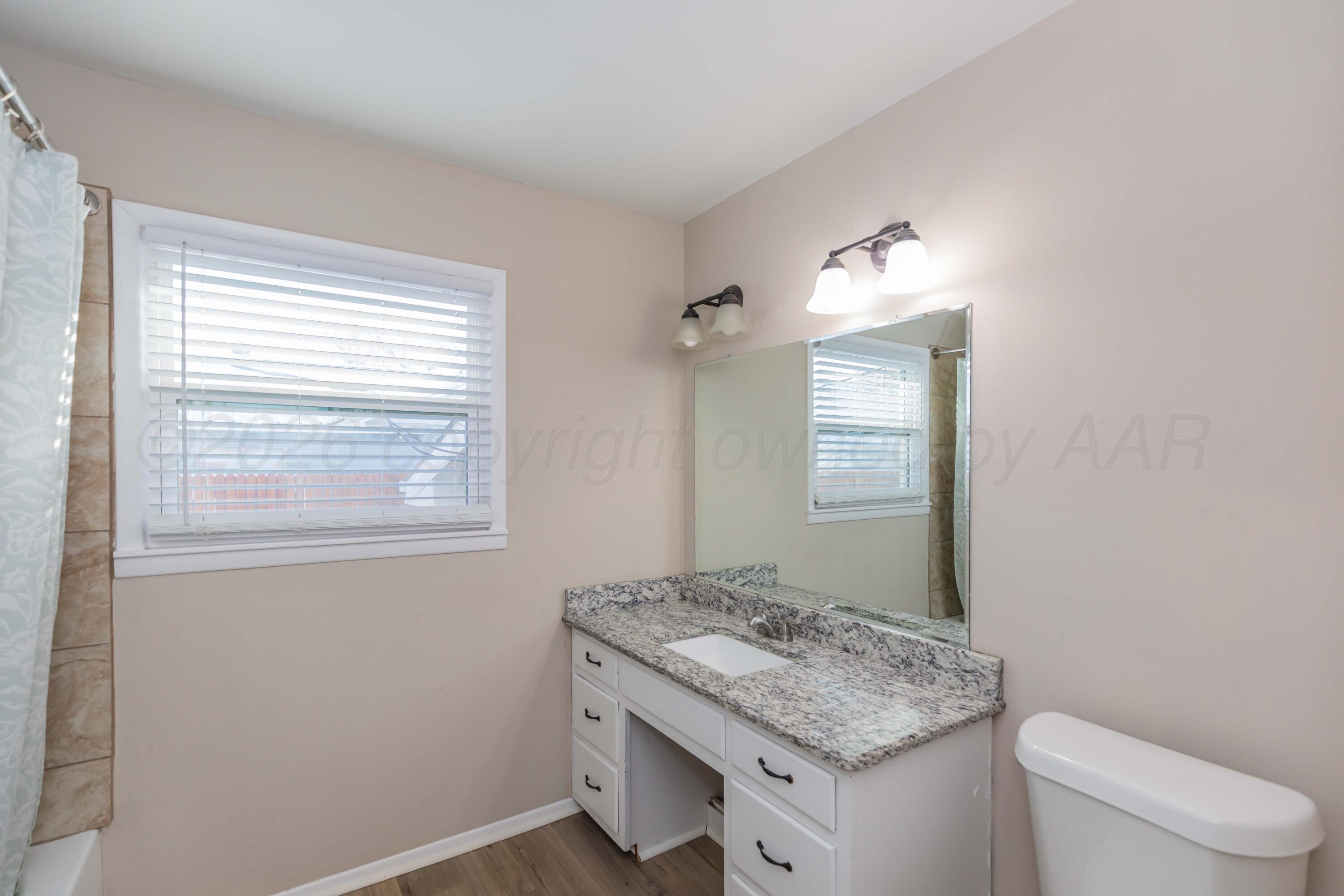 105 Smith Street Borger, TX 79007 - Photo 22 of 26 a bathroom with a granite countertop sink and a mirror
