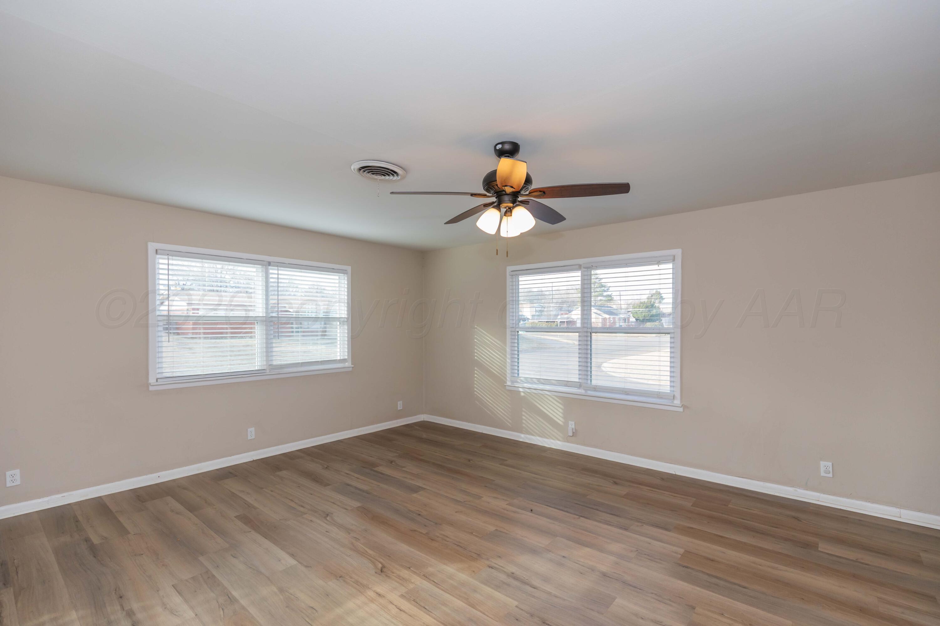 105 Smith Street Borger, TX 79007 - Photo 5 of 26 wooden floor in an empty room with a window