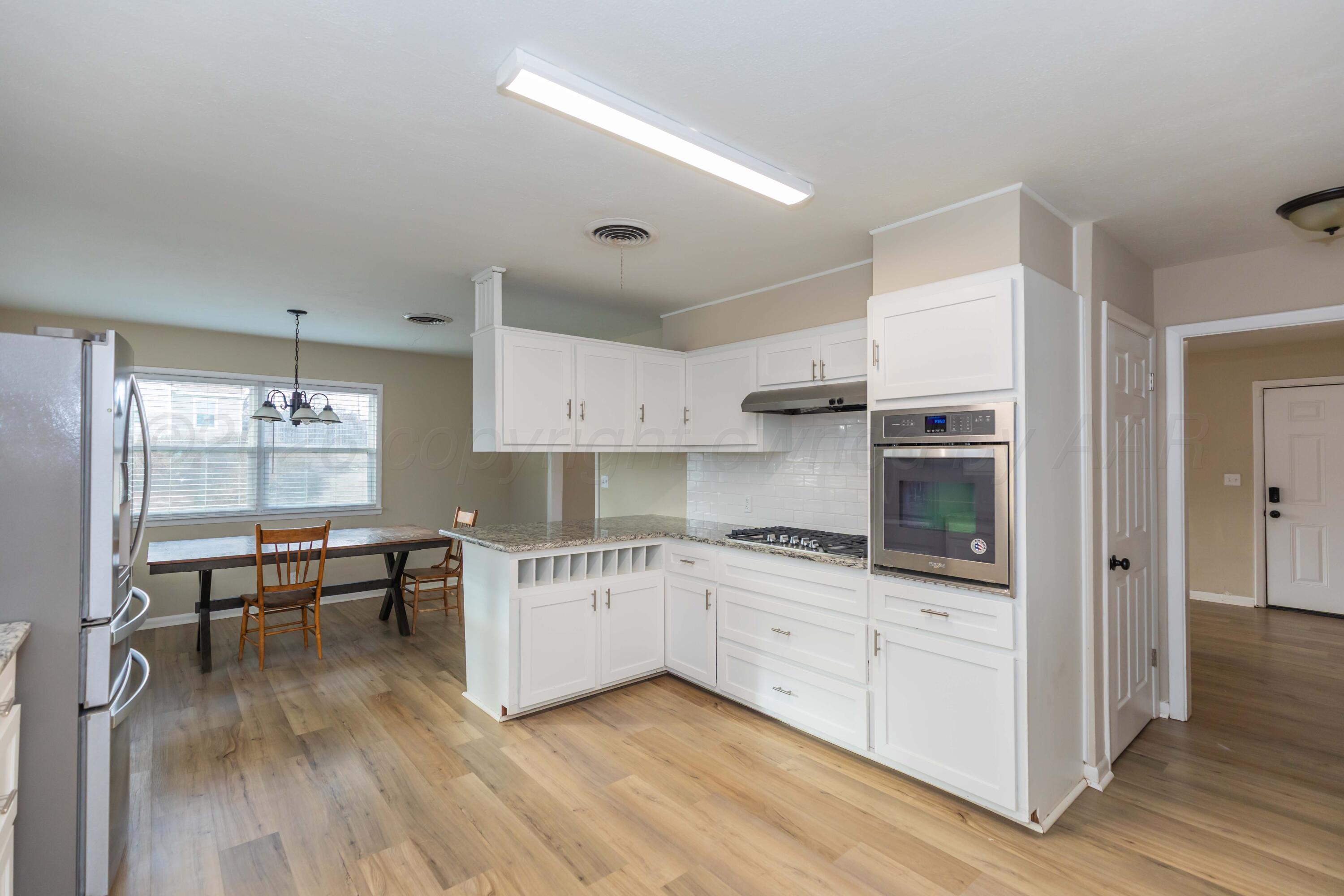 105 Smith Street Borger, TX 79007 - Photo 9 of 26 a kitchen with granite countertop a stove a sink and a refrigerator