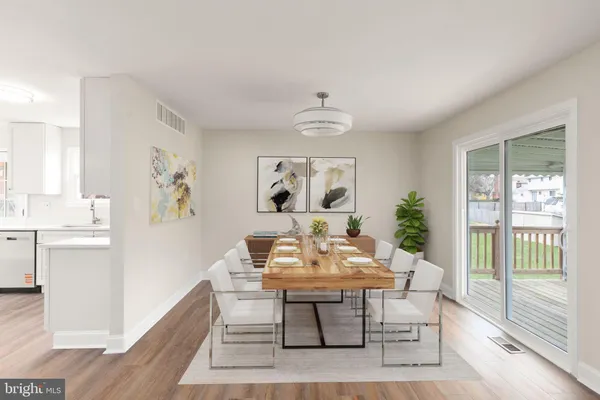 a dining room with wooden floor and a chandelier