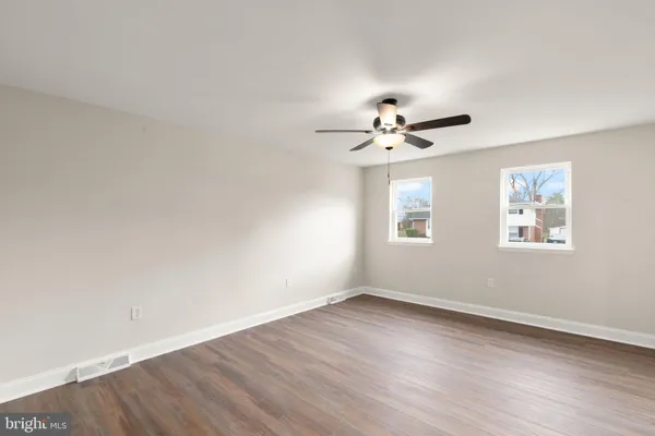 a view of a room with wooden floor and ceiling fan