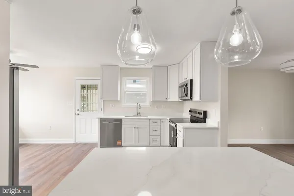 a large white kitchen with cabinets a sink and dishwasher