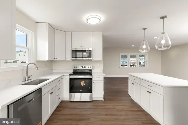 a kitchen with stainless steel appliances granite countertop a sink dishwasher a stove and a refrigerator