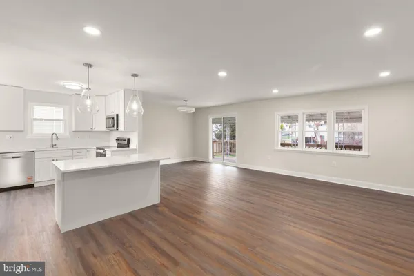 a large white kitchen with wooden floors and white cabinets