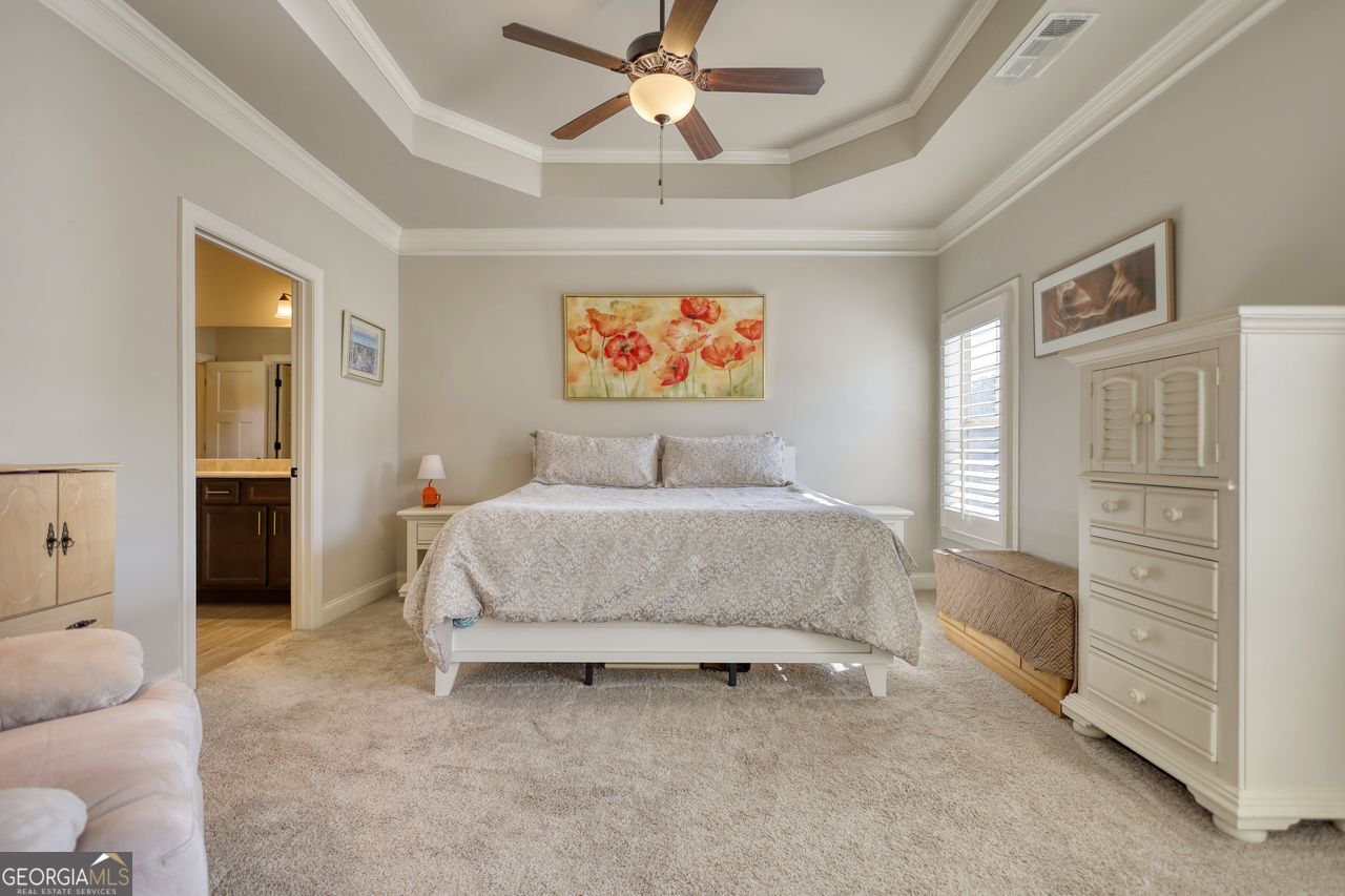 246 Club Drive Monroe, GA 30655 - Photo 12 of 18 a bedroom with a bed and a chandelier