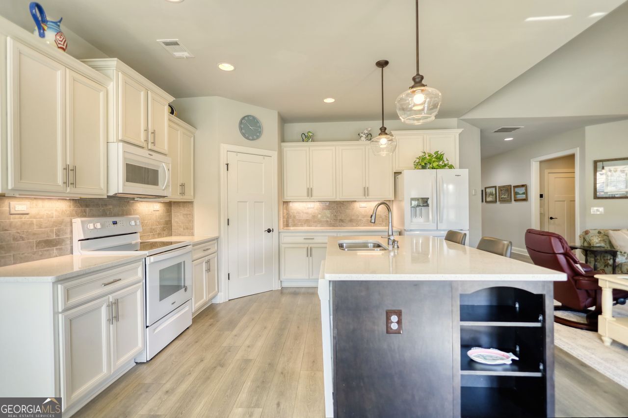 246 Club Drive Monroe, GA 30655 - Photo 4 of 18 a large kitchen with stainless steel appliances kitchen island granite countertop a sink and cabinets
