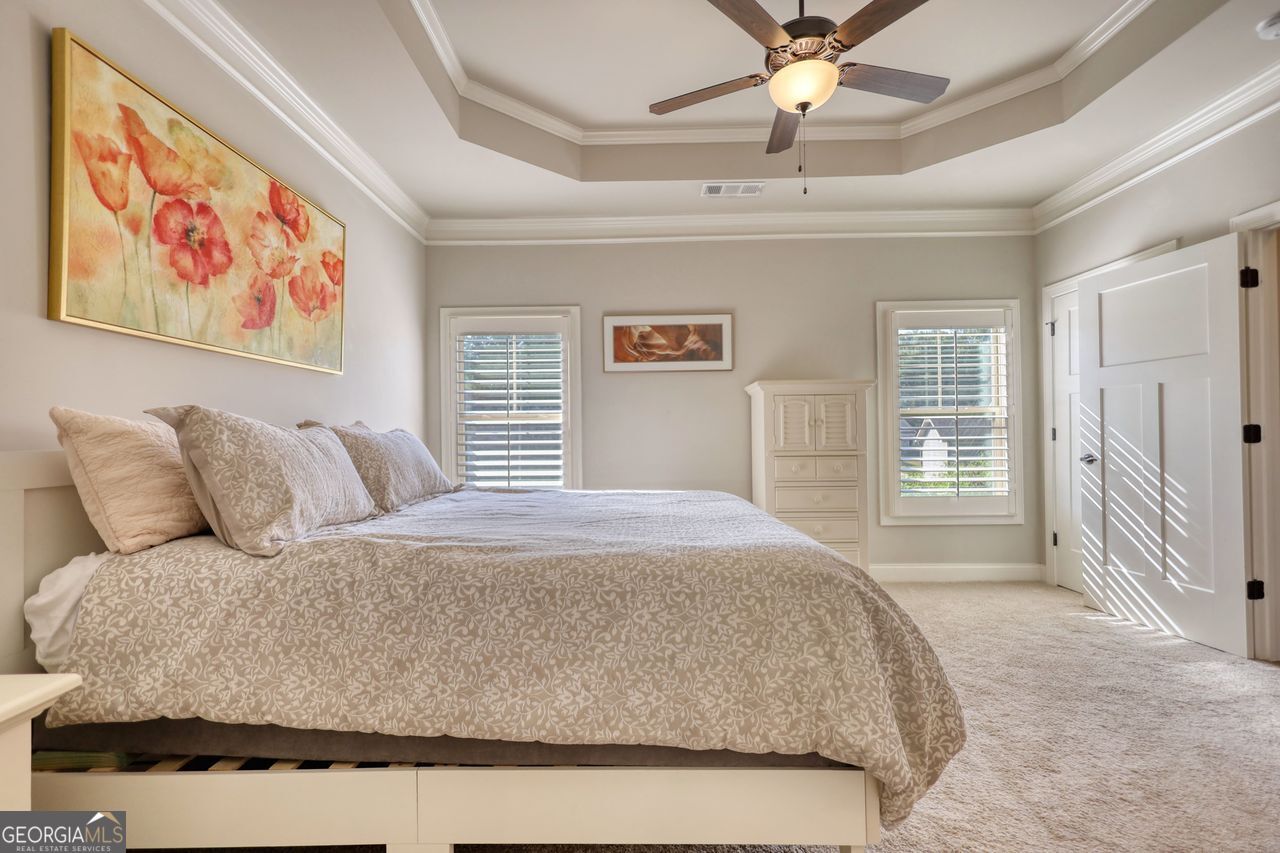 246 Club Drive Monroe, GA 30655 - Photo 7 of 18 a bedroom with a large bed and a chandelier