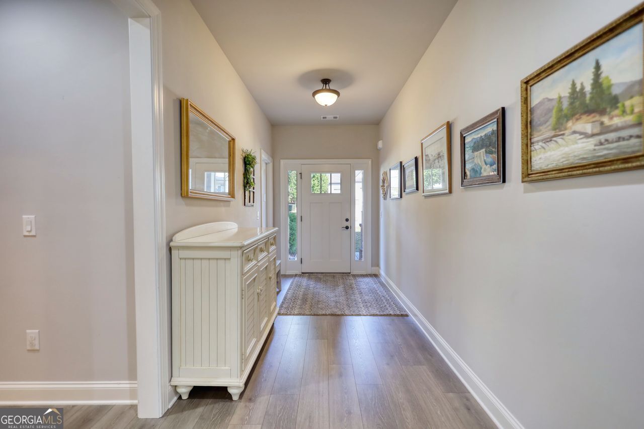 246 Club Drive Monroe, GA 30655 - Photo 9 of 18 a view of a hallway with wooden floor and staircase
