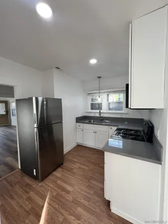 a kitchen with stainless steel appliances granite countertop a refrigerator a stove and a sink