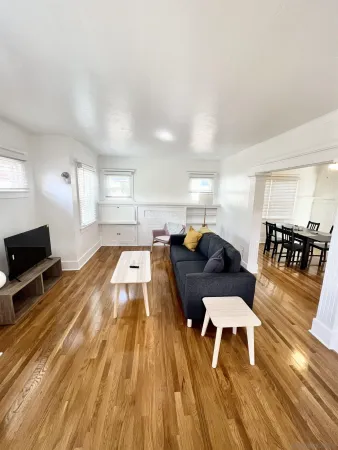 a living room with furniture and a wooden floor