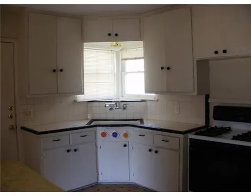 a kitchen with granite countertop white cabinets and white appliances