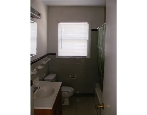 a bathroom with a toilet a sink and a window