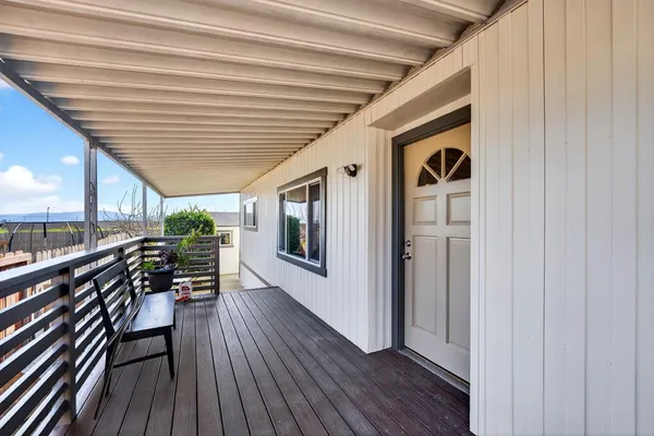 a hallway with wooden floor stairs and furniture