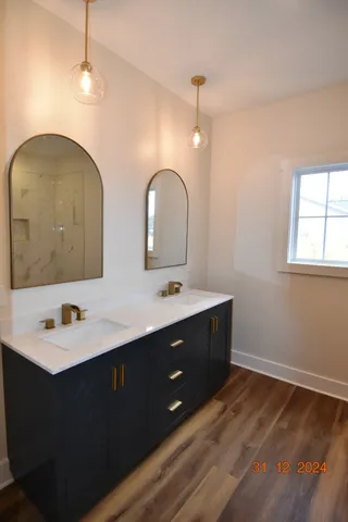 a bathroom with a double vanity sink a mirror and shower