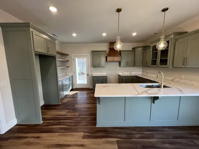 a kitchen with a sink stove and wooden floor
