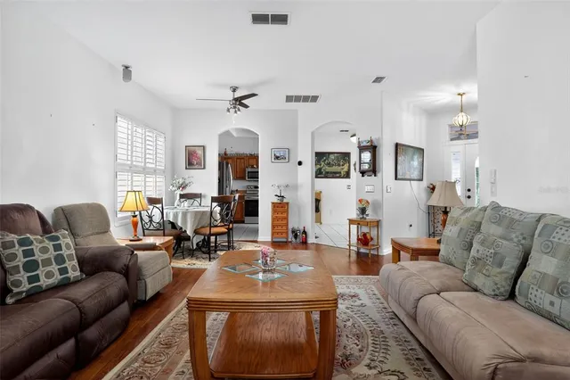 a living room with furniture kitchen view and a chandelier
