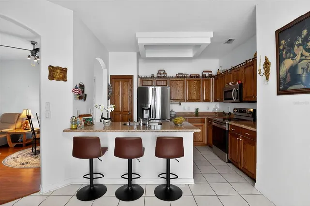 a kitchen with stainless steel appliances kitchen island granite countertop a sink and cabinets