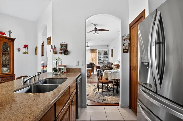 a kitchen with stainless steel appliances granite countertop a refrigerator a sink a stove and island