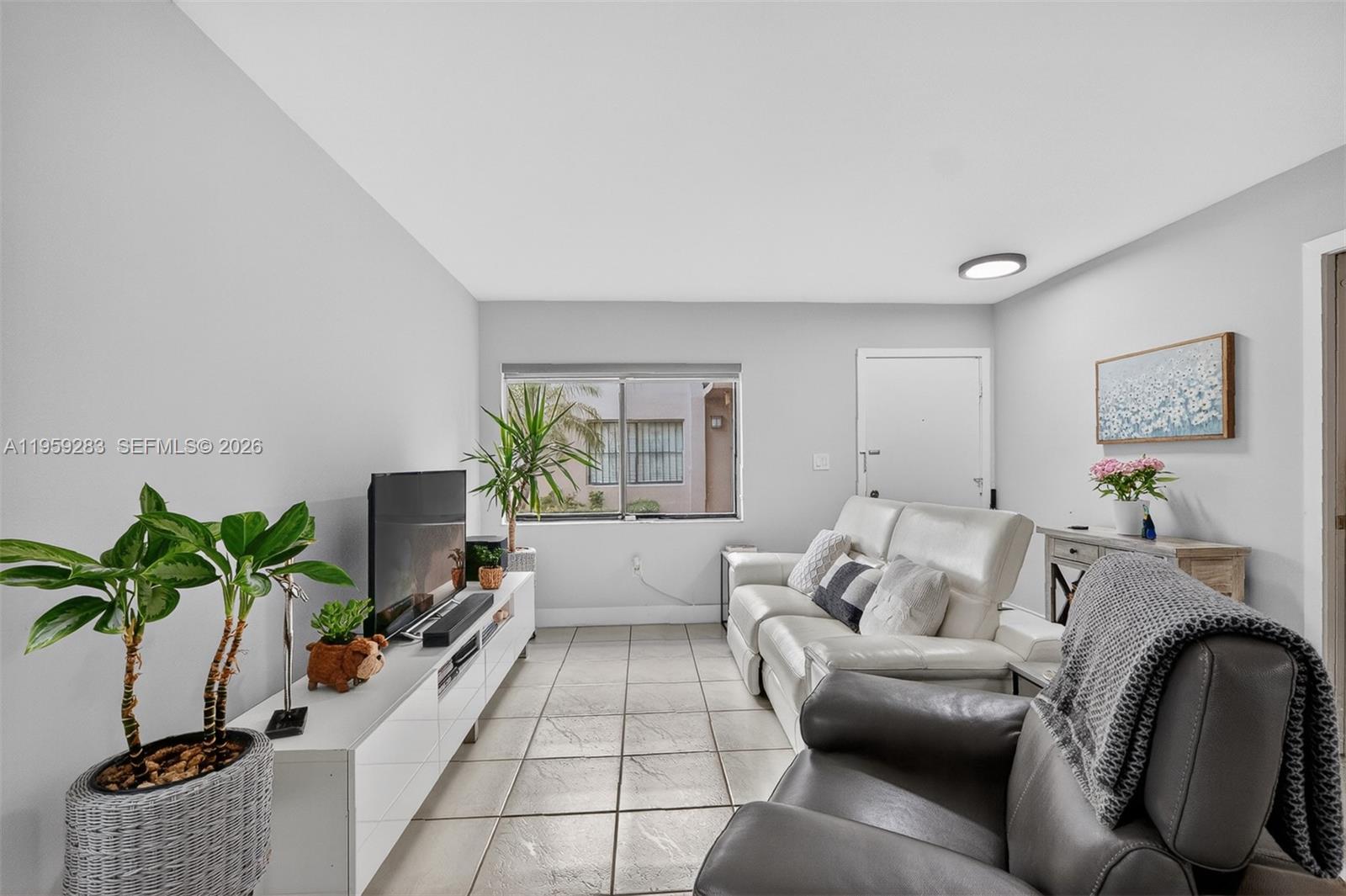 8540 Southwest 133rd Avenue Road, Unit 112 Miami, FL 33183 - Photo 5 of 23 a living room with furniture potted plant and a window