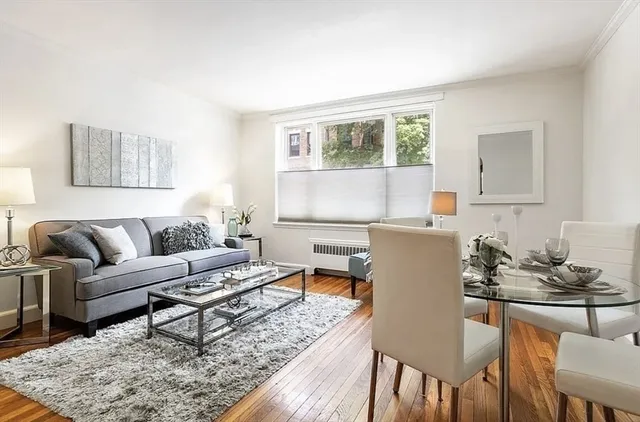 a living room with a couch dining table and a window