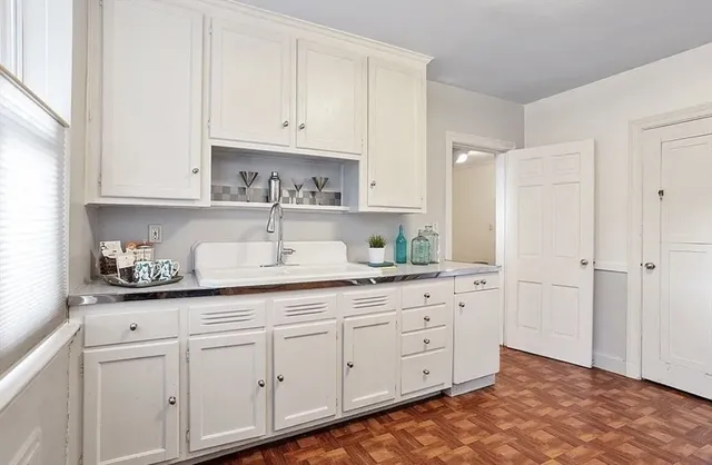 a kitchen with white cabinets and white appliances