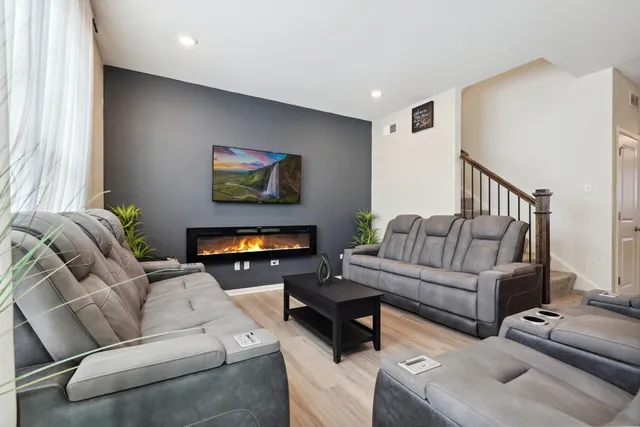 a living room with furniture a fireplace and a flat screen tv