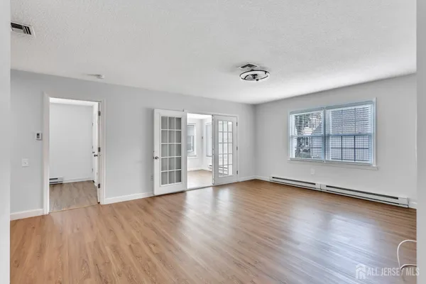 an empty room with wooden floor and windows