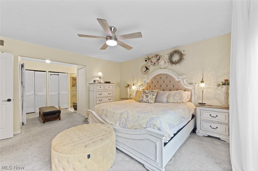 171 Granger Road, Unit 107 Medina, OH 44256 - Photo 24 of 41 Carpeted bedroom featuring a ceiling fan with integrated lighting, a wide doorway opening to bi-fold closet doors, and wall-to-wall carpeting