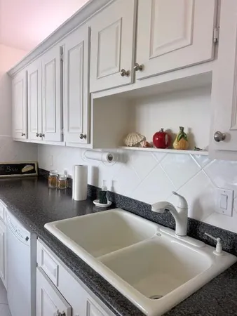 a kitchen with white cabinets and a sink