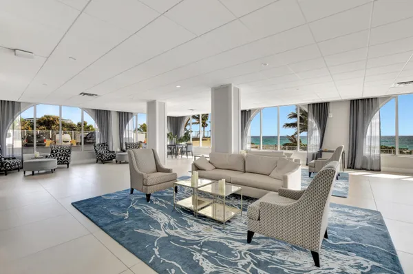 a living room with furniture and floor to ceiling window